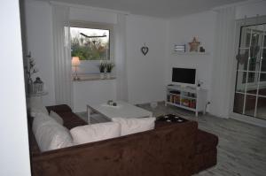 a living room with a couch and a tv at Strandstern mit Wallbox in Wremen