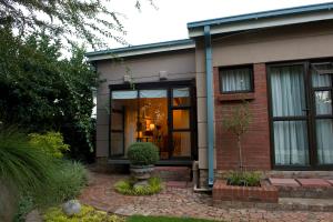 a house with a glass door on a patio at Primavera Guest House in Bloemfontein