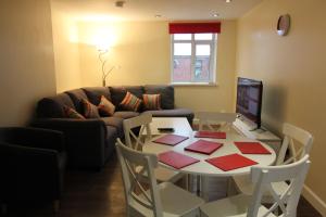 un salon avec une table et un canapé dans l'établissement Sal's Hideout - City Centre - Parking - 2BR, à Belfast