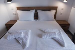 a white bed with two white towels on it at House Okto in Alexandroupoli