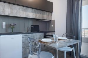 a kitchen with a table with two chairs and a counter at House Okto in Alexandroupoli +12 photos