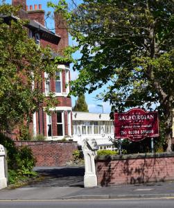 un panneau pour une école devant un bâtiment en briques dans l'établissement Salfordian, à Southport