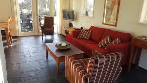 een woonkamer met een rode bank en een tafel bij Vakantiehuis "Aan de Zandweg" in Roderesch