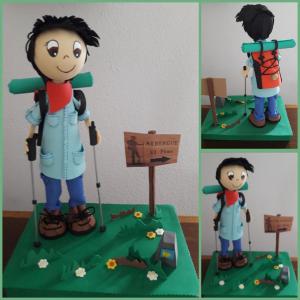 a cake with a toy figure of a boy on a table at Albergue El Pino in Cóbreces