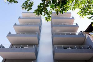 two balconies of an apartment building with trees at House Okto in Alexandroupoli