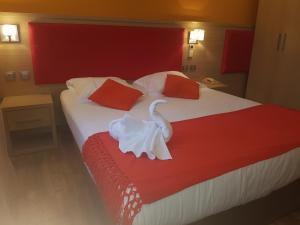 a hotel room with a bed with a swan on it at Le Petit Mas De Marie in La Tour-dʼAigues