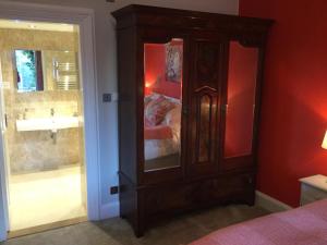 1 dormitorio con armario de madera y espejo en Grosmont House, en Grosmont 32 fotos más