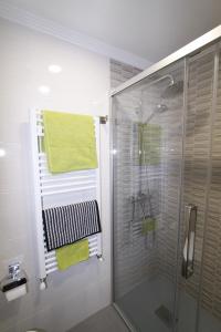 La salle de bains est pourvue d'une douche et d'une serviette verte. dans l'établissement Apartamento con encanto y vistas en playa San Lorenzo, à Gijón