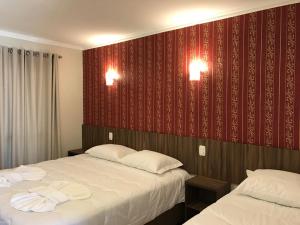 马沙蒂纽Hotel Villa das Termas Machadinho的酒店客房,设有两张床和红色的墙壁