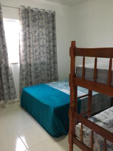 a bedroom with a bunk bed and a window at Aconchegante Casa de Temporada Araruama in Araruama