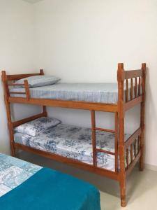 two bunk beds in a room with a bed at Aconchegante Casa de Temporada Araruama in Araruama