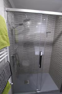La salle de bains est pourvue d'une douche avec une porte en verre. dans l'établissement Apartamento con encanto y vistas en playa San Lorenzo, à Gijón