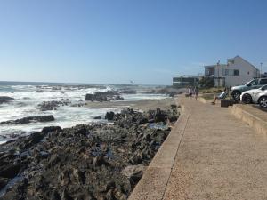a view of a beach with rocks and the ocean at Ocean Breeze Bloubergstrand in Bloubergstrand