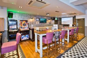 a restaurant with a table and chairs and a video game at The Abbey Inn in Paisley