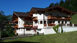 ein großes weißes Gebäude mit Balkonen auf einem Hügel in der Unterkunft Apartment Bachmann in Oberau