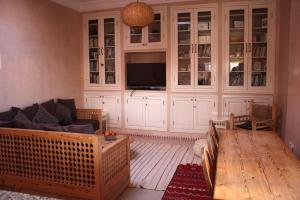 a living room with a couch and a tv at Tilily Apartment in Mirleft