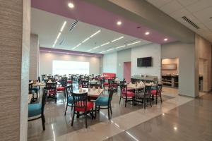 una grande sala da pranzo con tavoli e sedie di CHN Hotel Monterrey Aeropuerto, Trademark by Wyndham a Monterrey