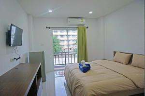 a bedroom with a bed with a desk and a window at A.D. Living in Hua Hin