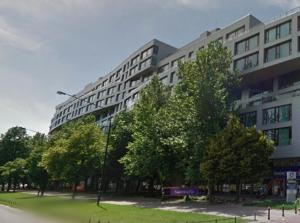 ワルシャワにあるGrójecka 194 - cozy studio by Homeprimeの目の前に木々が生い茂る大きな建物