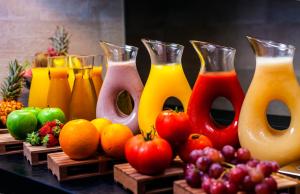 a group of vases filled with different types of juice at Barceló Teguise Beach - Adults Only in Costa Teguise