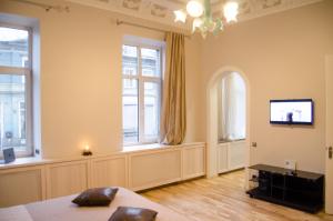 sypialnia z łóżkiem, telewizorem i oknami w obiekcie City Inn Riga Apartment, Barons promenade with parking w Rydze