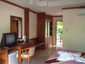 1 dormitorio con 1 cama y escritorio con TV en Starlight Resort Koh Phangan, en Thong Nai Pan Yai