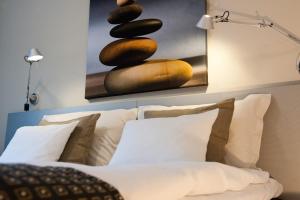 Un dormitorio con una cama con almohadas y una pintura en Hotel Birger Jarl, en Estocolmo