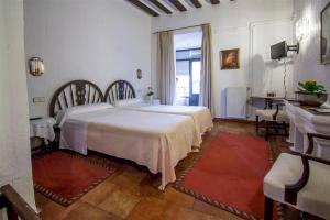 a hotel room with a bed, table and chairs at Posada San José in Cuenca