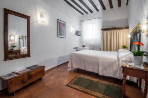 a hotel room with a bed, table and a mirror at Posada San José in Cuenca