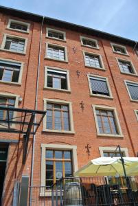 un edificio alto de ladrillo con ventanas y sombrilla en Steffis Hostel Heidelberg, en Heidelberg