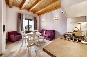 GiarratanaにあるAruciméli Rural Resortのキッチン、リビングルーム(紫色の椅子、テーブル付)