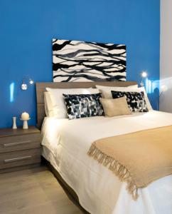 - une chambre avec un grand lit et un mur bleu dans l'établissement Lovely Corner: Perfect to visit Treviso/Venezia, à Trévise