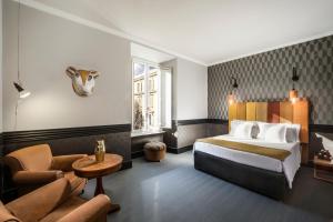 罗马Hotel Palazzo Manfredi – Small Luxury Hotels of the World的配有床和沙发的酒店房间