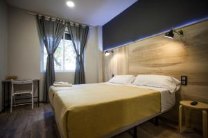 1 dormitorio con 1 cama grande y cabecero de madera en CC Atocha, en Madrid