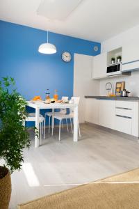 une cuisine avec une table blanche et un mur bleu dans l'établissement Lovely Corner: Perfect to visit Treviso/Venezia, à Trévise