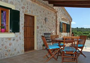 une terrasse avec une table et des chaises dans une maison dans l'établissement Ca Na Cati, à Pollença