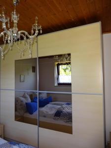 Dormitorio con cama con espejo y lámpara de araña en Haus Seeliger en Brand