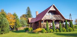 une grande maison en bois avec un toit rouge dans l'établissement Sznureczki, à Przewóz