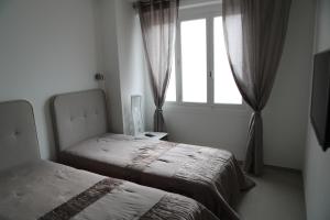 1 dormitorio con 2 camas y ventana en 3P luxe proche Croisette en Cannes