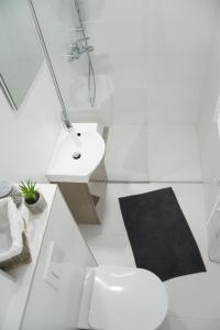 a white bathroom with a toilet and a sink at Bright & Stylish Studio Home, superbly located in Sarajevo