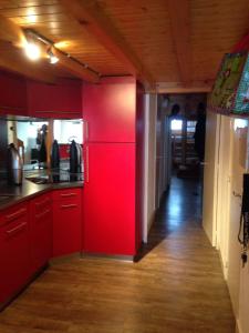 フレーヌにあるFlaine Forum i1 Cassiopée Duplex Mezzanines & Terrasseの赤いキャビネットと赤い壁のキッチン