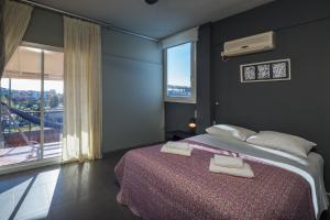 a bedroom with a bed with two white towels on it at Virgo - Loft with Spectacular View to Acropolis in Athens