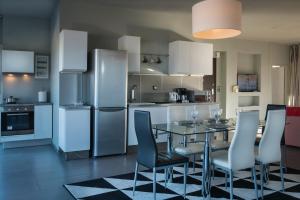 a kitchen with a table and chairs and a refrigerator at Virgo - Loft with Spectacular View to Acropolis in Athens