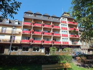 een groot gebouw met rode balkons in een straat bij Hotel Moselkern in Moselkern