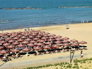 a bunch of umbrellas and chairs on a beach at Casa Del Mar in Roseto degli Abruzzi