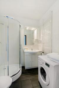 a bathroom with a washing machine and a sink at Apartament Poniatowskiego - Komfortowe Noclegi in Piaseczno