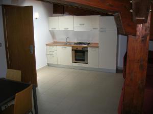 a kitchen with white cabinets and a stove top oven at Casa Del Mar in Roseto degli Abruzzi