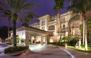 un grand bâtiment avec des palmiers devant lui dans l'établissement Trianon Bonita Bay Hotel, à Bonita Springs