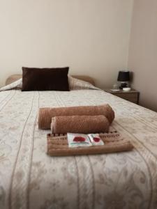 Una cama con dos toallas y un libro. en Full Rooms en Kyustendil