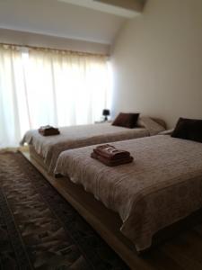 two beds sitting in a bedroom with a window at Full Rooms in Kyustendil